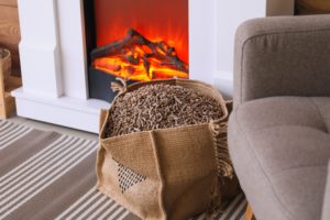 Bag,with,wood,pellets,near,fireplace,in,living,room