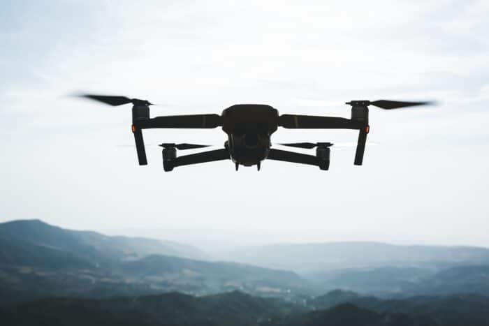Folding,small,drone,is,flying,over,the,mountains